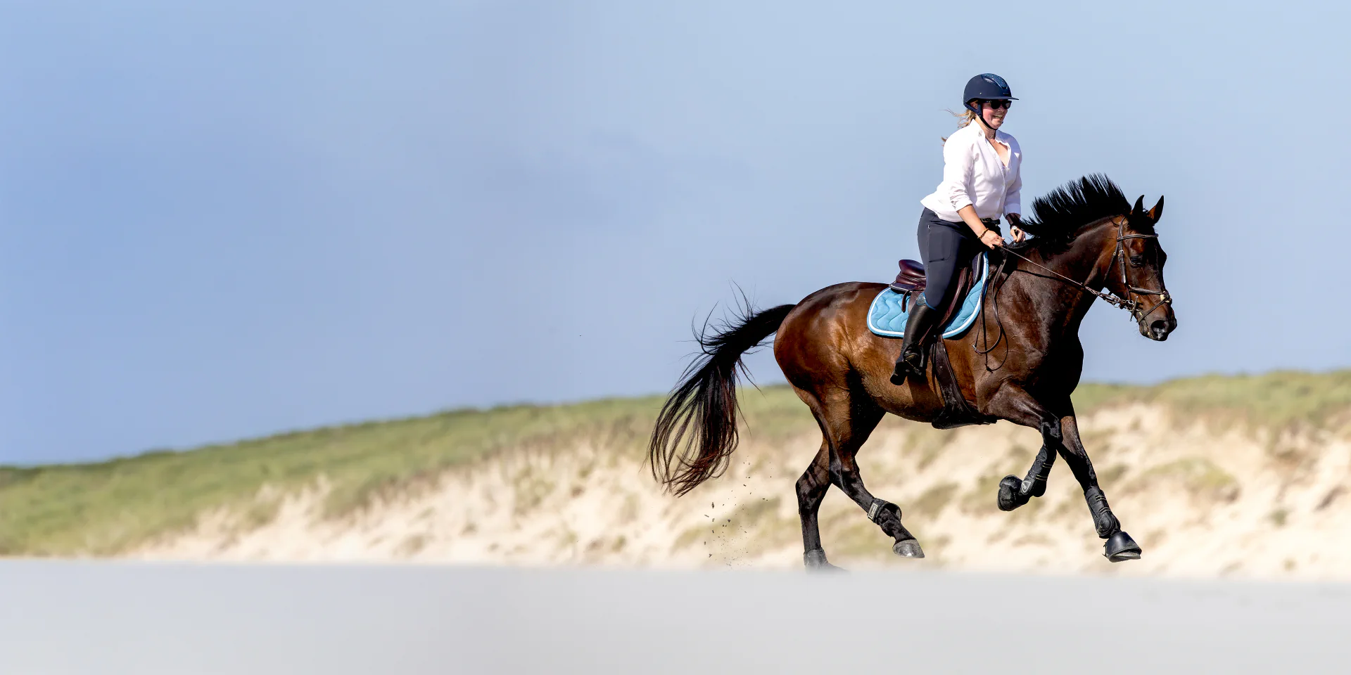 Cavalière au galop sur une plage lors d’un événement équestre